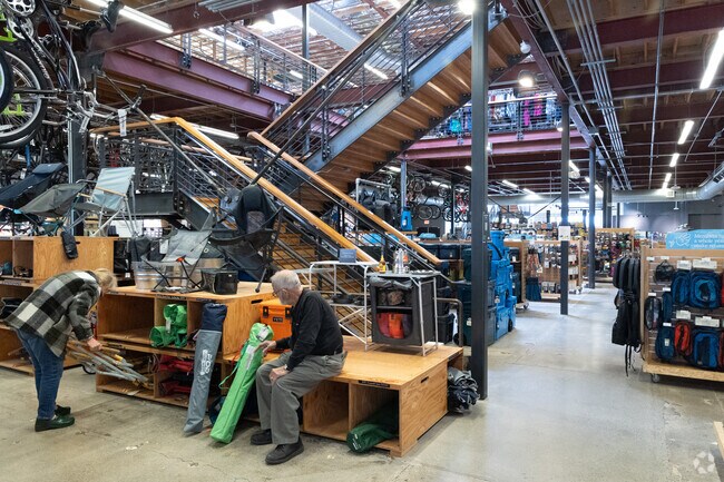 a couple is testing caping equipment at the Corte Madera REI store.