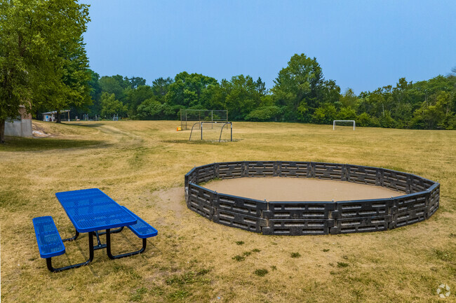 A small gaga ball pit and picnic bench sit near the fields at John Muir Elementary School.