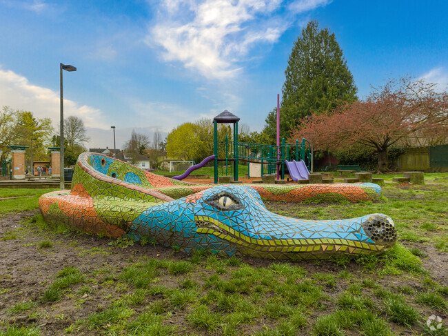 Colorful mosaic alligator bench rest in front of Irvington Elementary School playground.