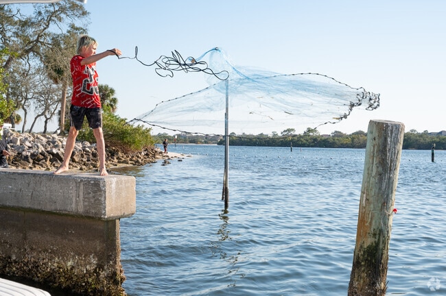 A young angler casts his net for bait fish at Anclote River Park.