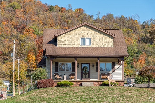 A quaint home abuts a wooded hill in Lansing.
