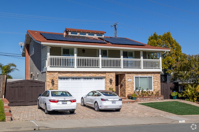 A solar-equipped home in Telescope Hills, Millbrae, features a stone facade and wraparound balcony.