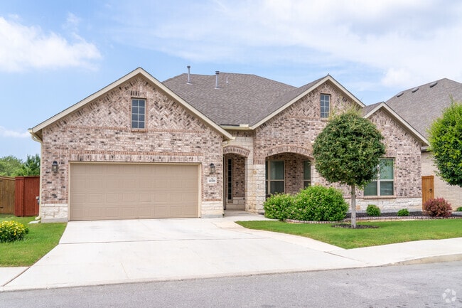 A modern brick home stands proud with a lush front yard, adding fresh curb appeal to the Fronterra at Westpointe neighborhood.