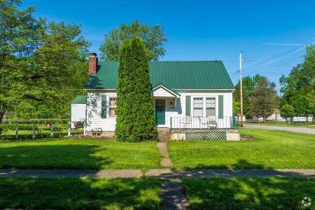 A classic cottage-style home with a green roof & large yard adds charm to Sheridan Park.