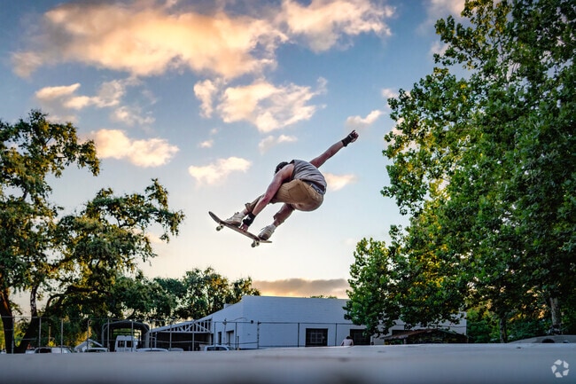 Man launches from large pool during sunset at the Humboldt Avenue Skate Park.