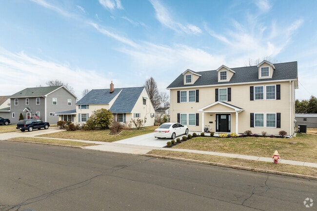 A Cape Cod home in Birch Valley, flanked by Colonial Revival and Georgian Revival houses.