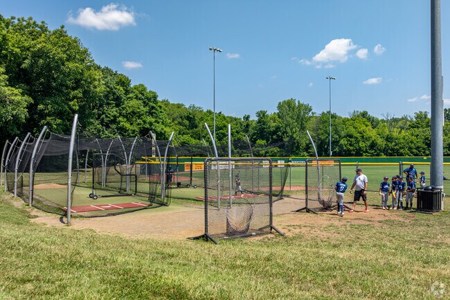 Ball players warm up at the batting cage at Jack Hughes Park.