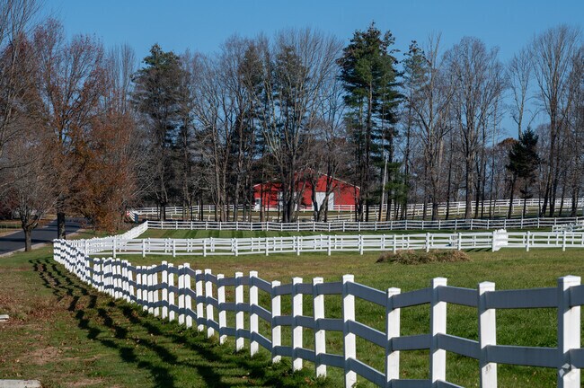 A white fence surrounds a farm in West Brookfield.