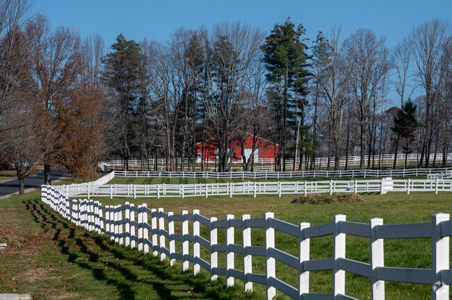 A white fence surrounds a farm in West Brookfield.