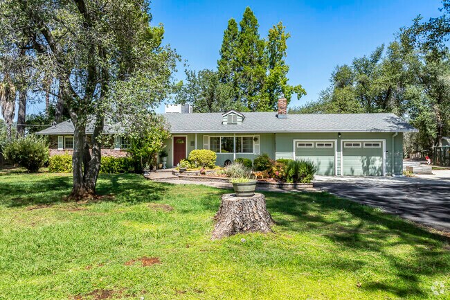 This older ranch-style home has a beautiful, landscaped yard with wood siding in Happy Valley.