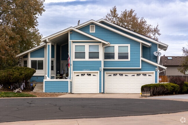 This multi level home in Smoky Hill features a three car garage and a covered porch.
