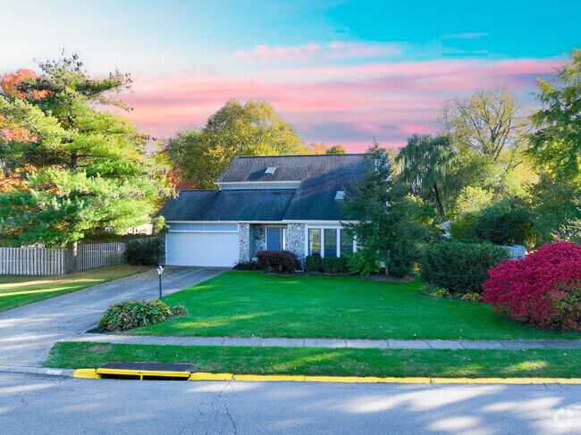 A beautiful sunset falls behind this cute mid-century home in Bellbrook.