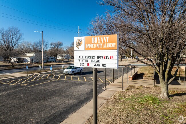 There is a sign for Bryant Opportunity Academy near the street.
