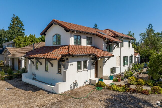 Xeriscape surrounds this white stucco home with a red clay roof.