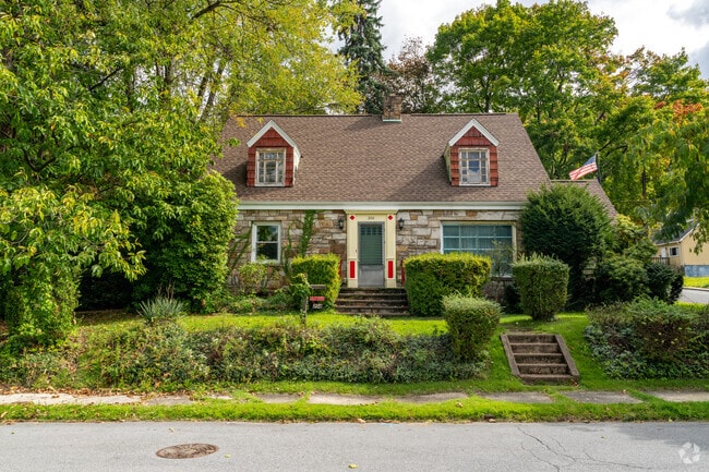 The cape cod homes of Coopersdale provide a scenic environment with lush greenery.