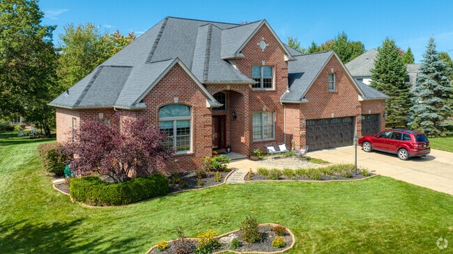 A brick colonial style home sits on a well-manicured lawn in Marshall Township.