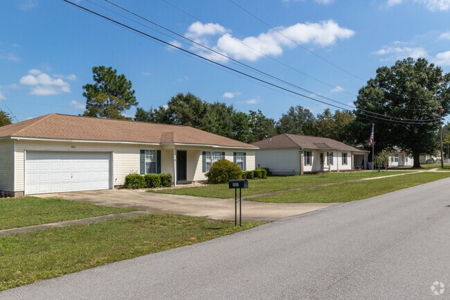 Quiet neighborhood streets, low ranch style homes, and blue sky in Holley, FL.