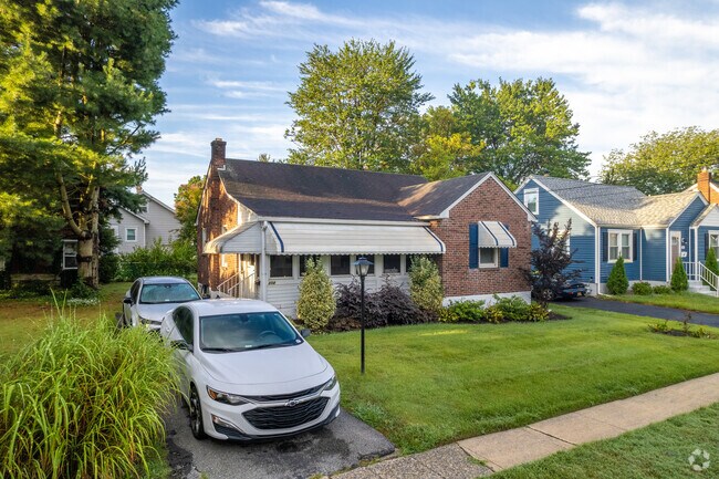 A lovely ranch house with glints of sunrise peaking through the trees.