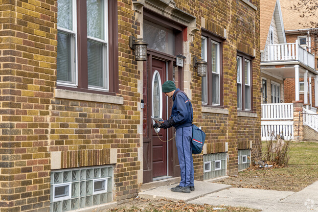 A mail carrier delivers the mail to a Triangle North Apartment building.