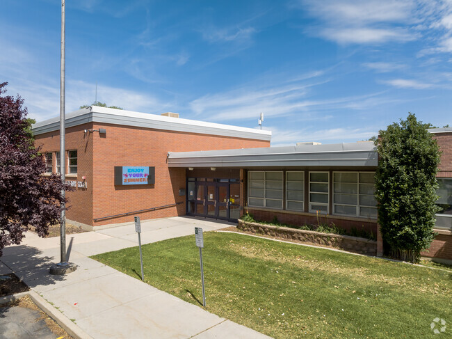 The front entrance at Liberty Elementary School has grass and trees.
