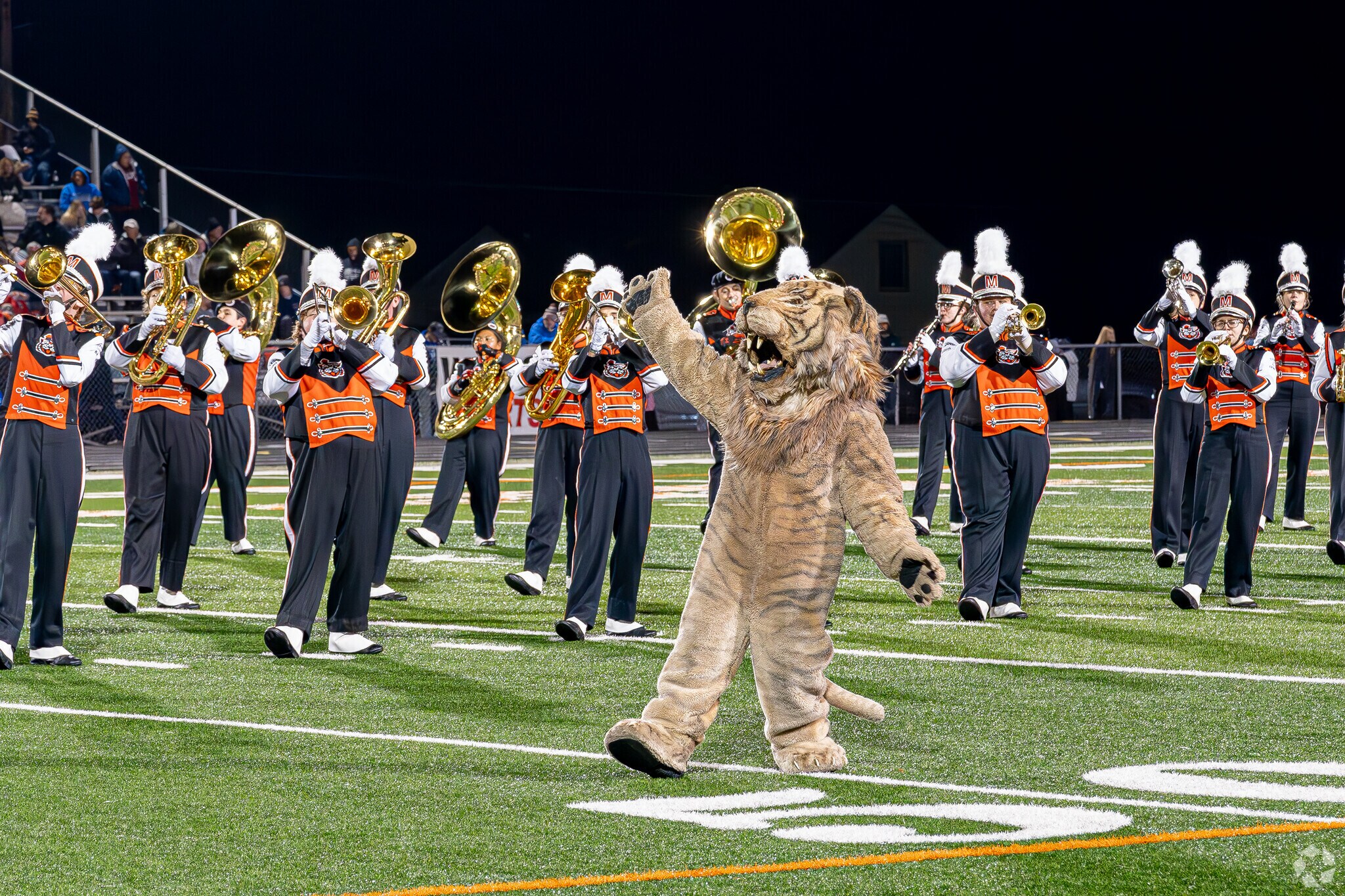 The Washington High School mascot of Downtown Massillon with the marching band during half-time.