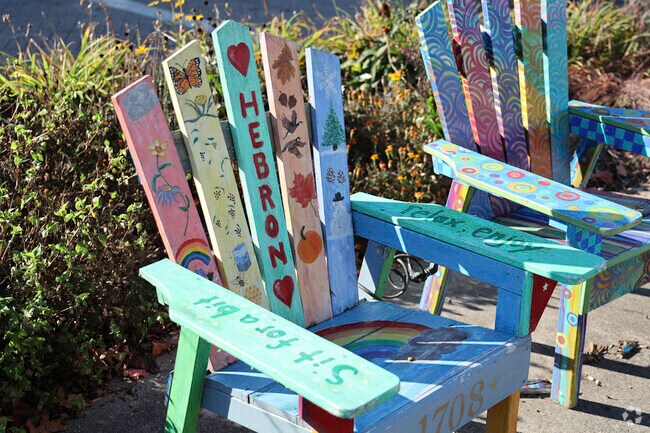 Community members adorn parts of their community with hand painted Adirondack chairs.