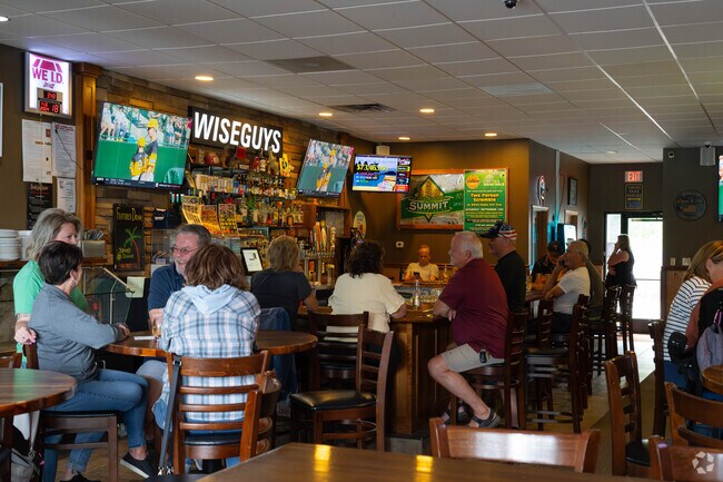 Inside Wiseguys Pizza & Pub, patrons enjoy slices and conversation.