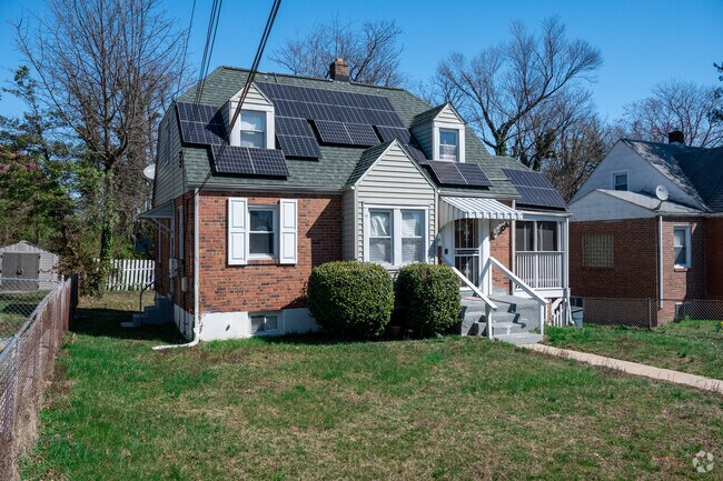 A cozy Coral Hills cottage features solar panels and plenty of green space for sustainable living.