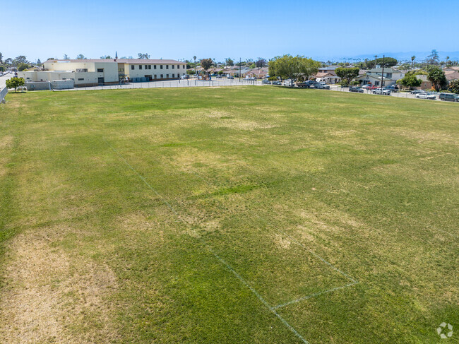 There is a large grass area for a game of kickball or soccer at Elm Street Elementary School.
