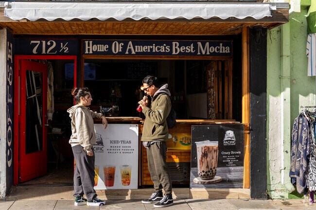 Locals enjoy drink spots and trendy shops along the Pacific Beach boardwalk.