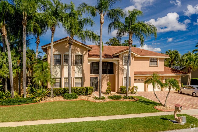 Palm trees surround this Mediterranean style home in the City of Coral Springs, FL.