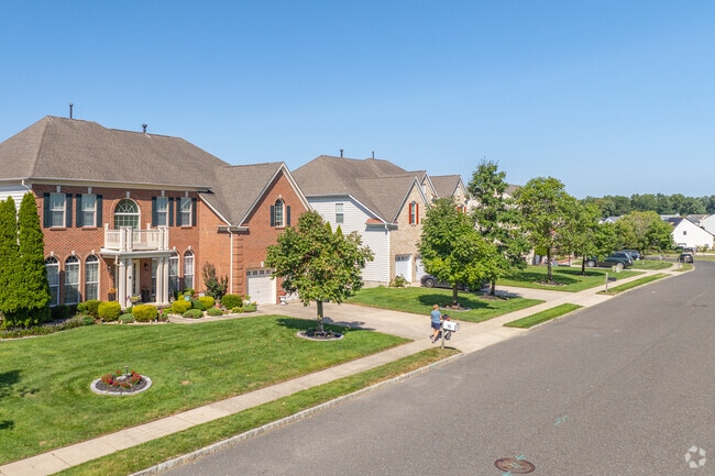 Walk down quiet sidewalks next to brick colonial revivals in Erial.