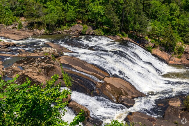 High Falls Lake in Towaliga Shores offers a beautiful view of cascading water, set against a backdrop of lush forest and peaceful walking trails.