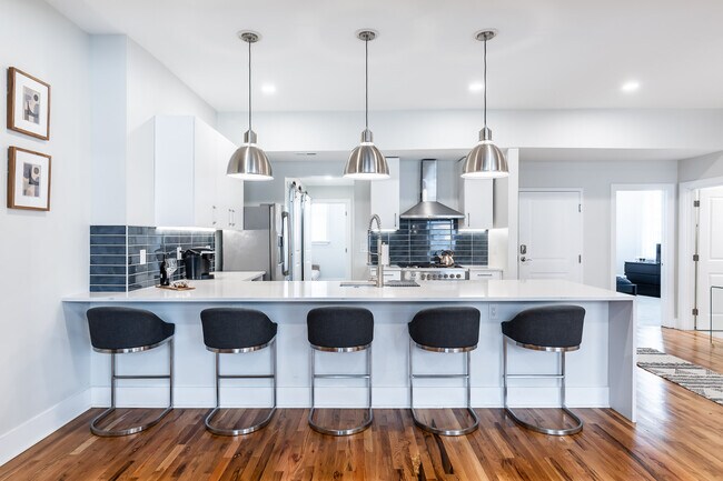 Very cool chefs kitchen with waterfall quartz counters