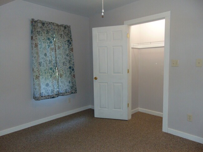 First bedroom with closet door open.