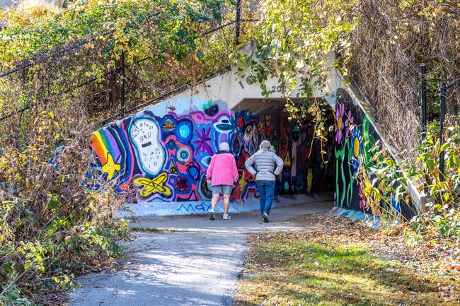 The Longfellow Nature Trail features a colorfully painted tunnel and a wooded path.