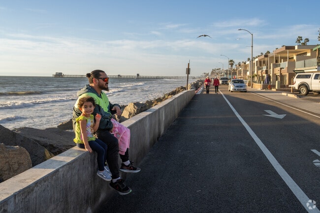 This dad and daughter are enjoying the sunset at the strand in. Oceanside near Fire Mountain.