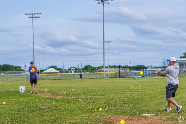 Friends take turns batting, pitching, and fielding at the Oak Ridge Community Park near Galliano.