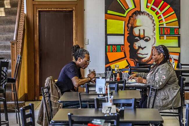 Sit down and enjoy the food and hospitality at Coffee Makes You Black in the Amani neighborhood.