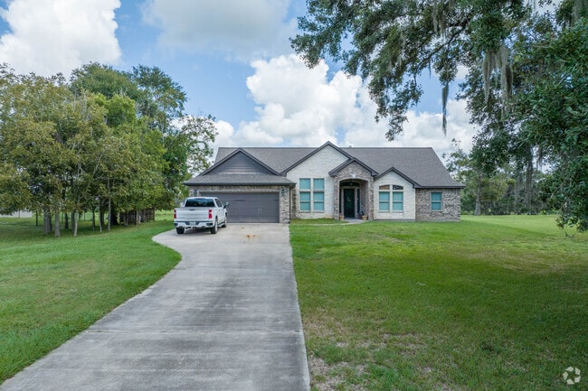 A long driveway leads to a four-bedroom home in Angleton, Texas.