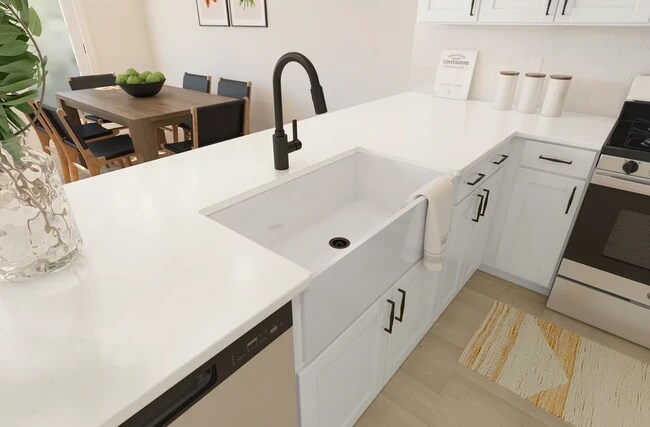 Kitchen with white apron-front sink and matte black fixtures