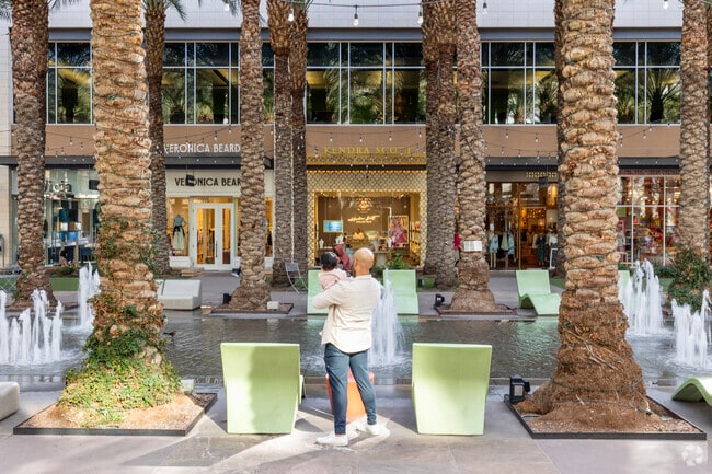 A father takes his child to explore the fountains at Scottsdale Fashion Square near Horizons.