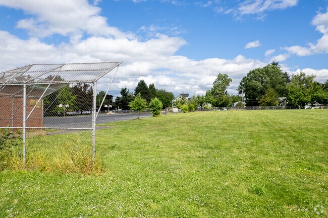 Backdrop and baseball field with the batters cage in frame.