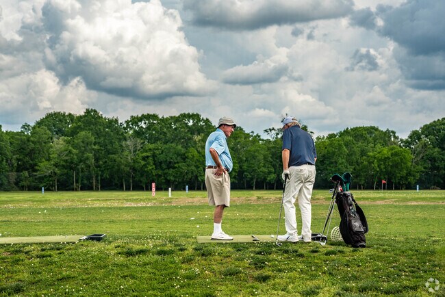 Two people talking on the driving range of Harpeth Valley Golf Center in Harpeth Valley Park.