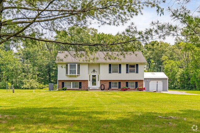 This classic Kingwood split-level sits proudly on a sprawling lot, framed by mature trees.