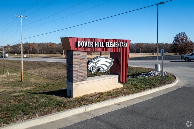 There is a sign for Dover Hills Elementary near the main road.