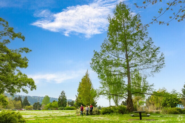 A family walks their dog along the paved paths of Cathedral Park.