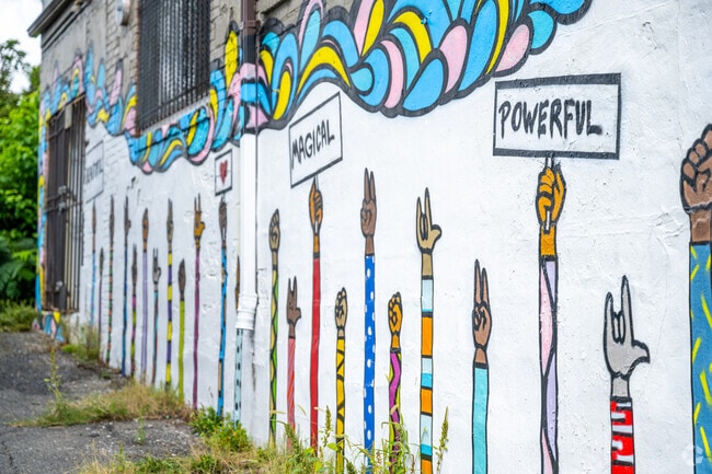A mural on a store in East Corner depicts many raised hands.