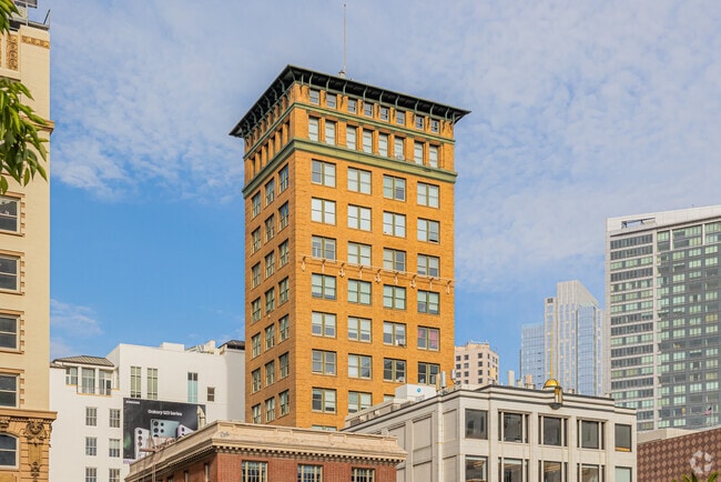 A brick apartment building towers above others in Downtown.