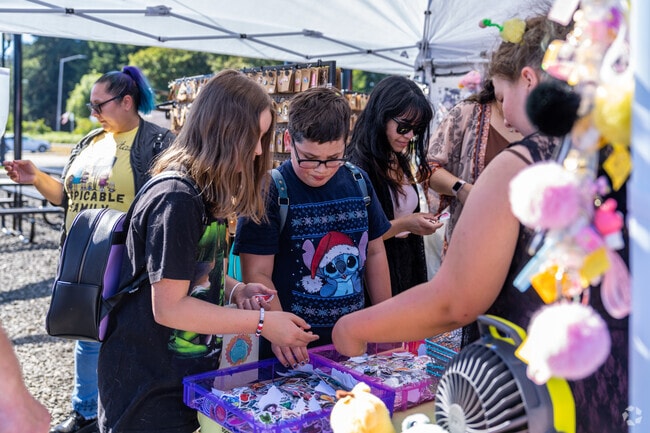 Kids are looking through some stickers at the Night Market @ The Depot.